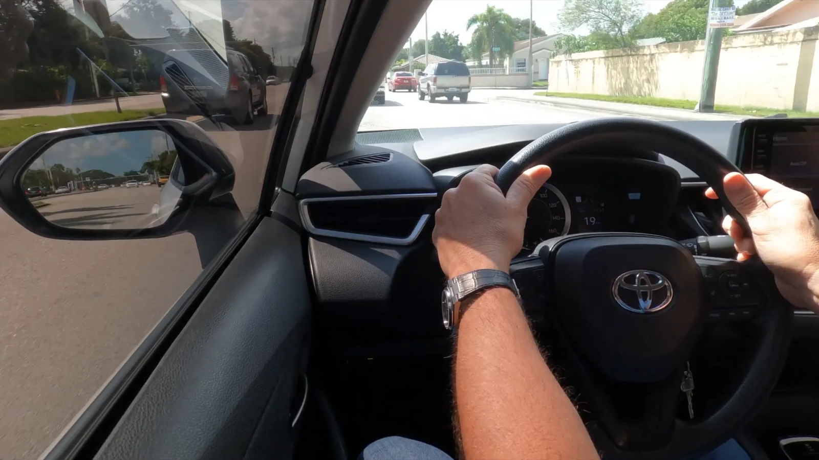 Vista del espejo mostrando las llantas delanteras del auto en el carril a incorporar