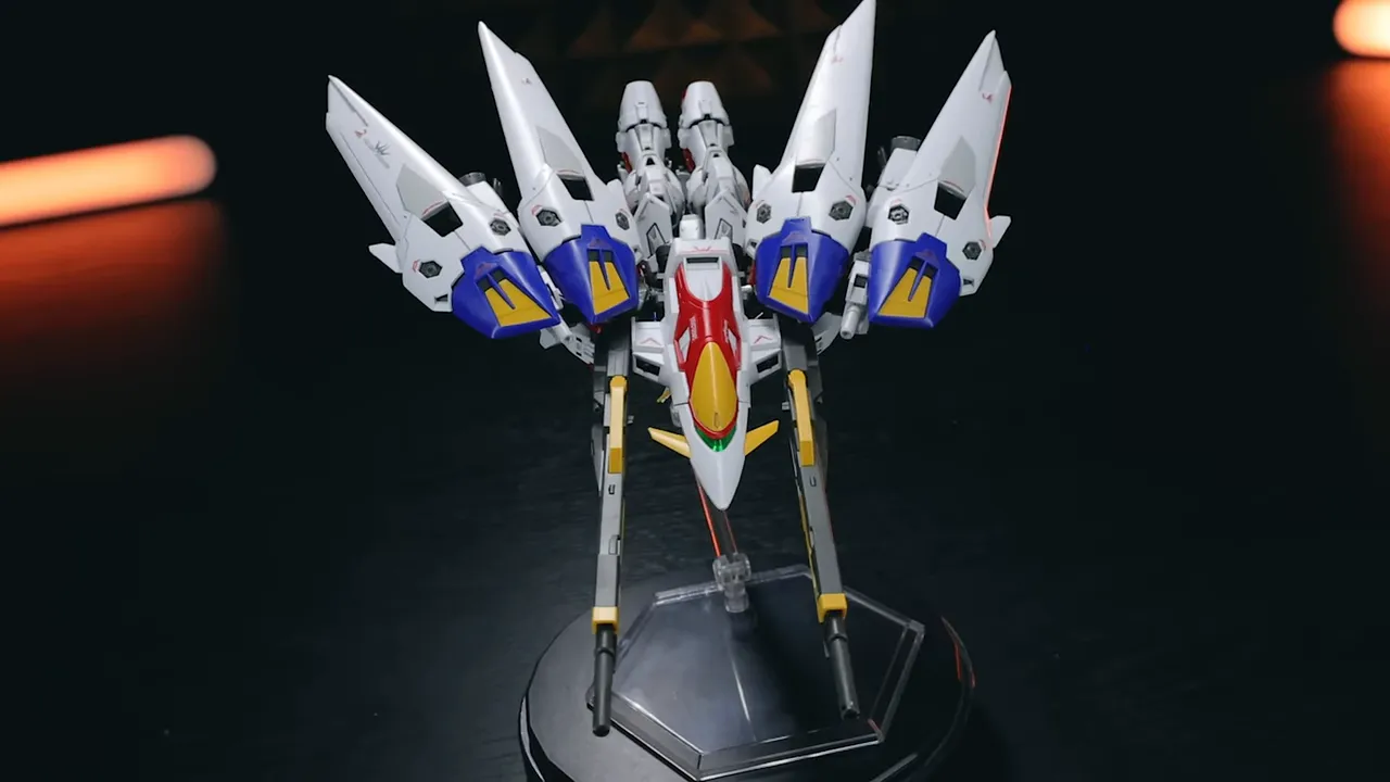 Bird Mode del RG Wing Gundam Zero con los Twin Busters y las alas desplegadas, en base de exhibición